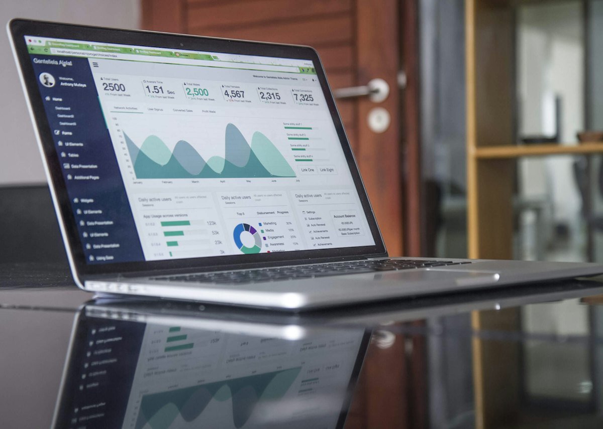 A laptop showing analytics on a glass-topped table