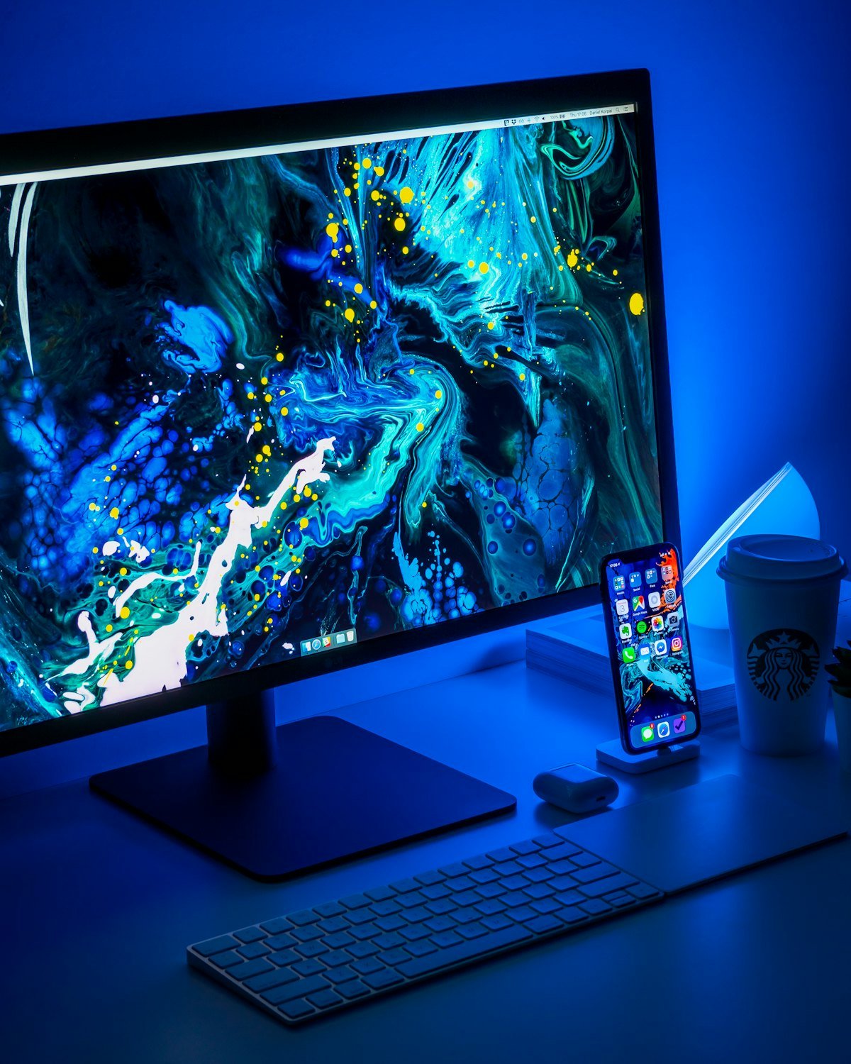 A desktop monitor turned on beside a keyboard