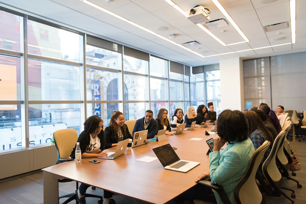 Colleagues around a wooden table with laptops