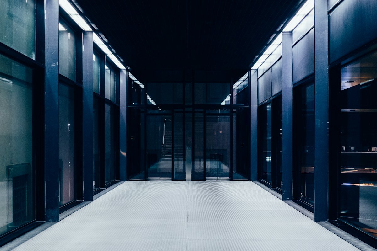 A data center corridor behind glass doors