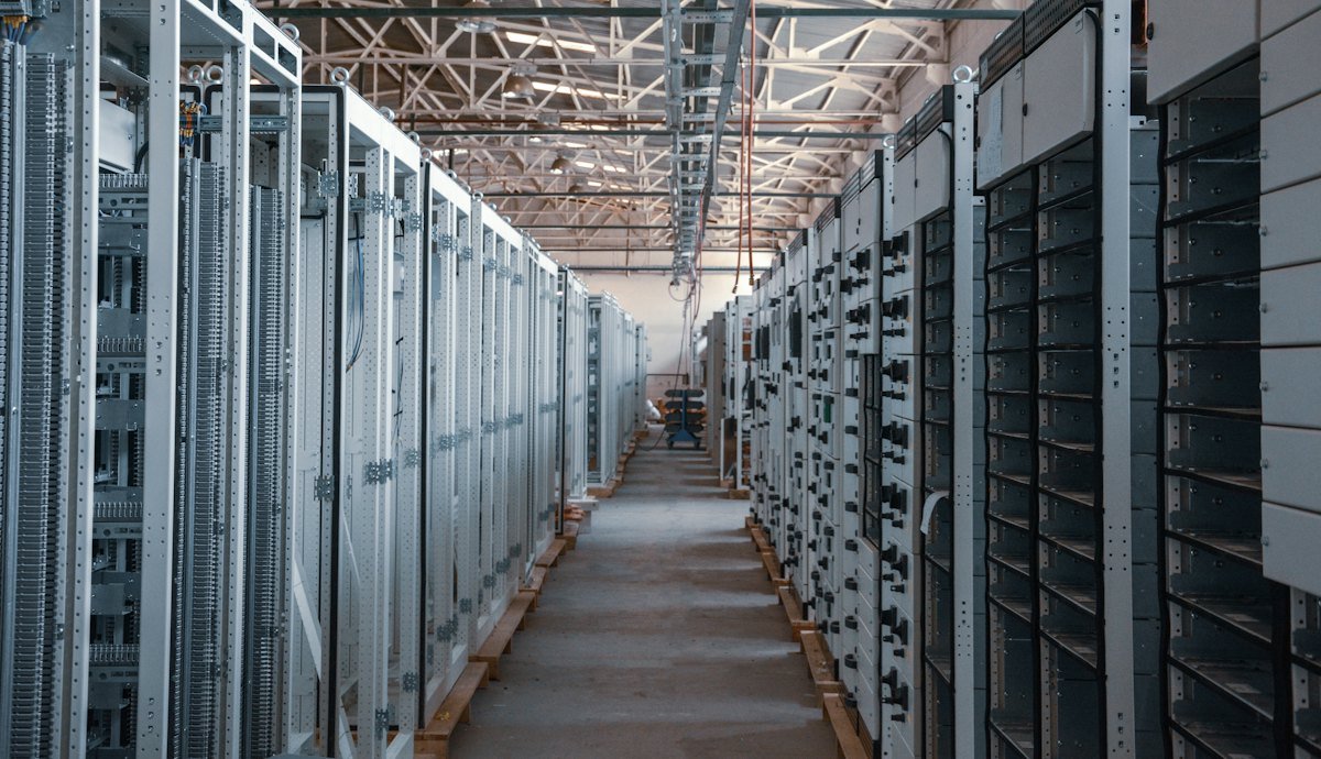 A server room aisle lined with metal equipment racks