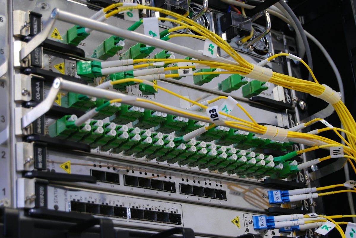 Fibre optic cables connected to a network switch in a rack