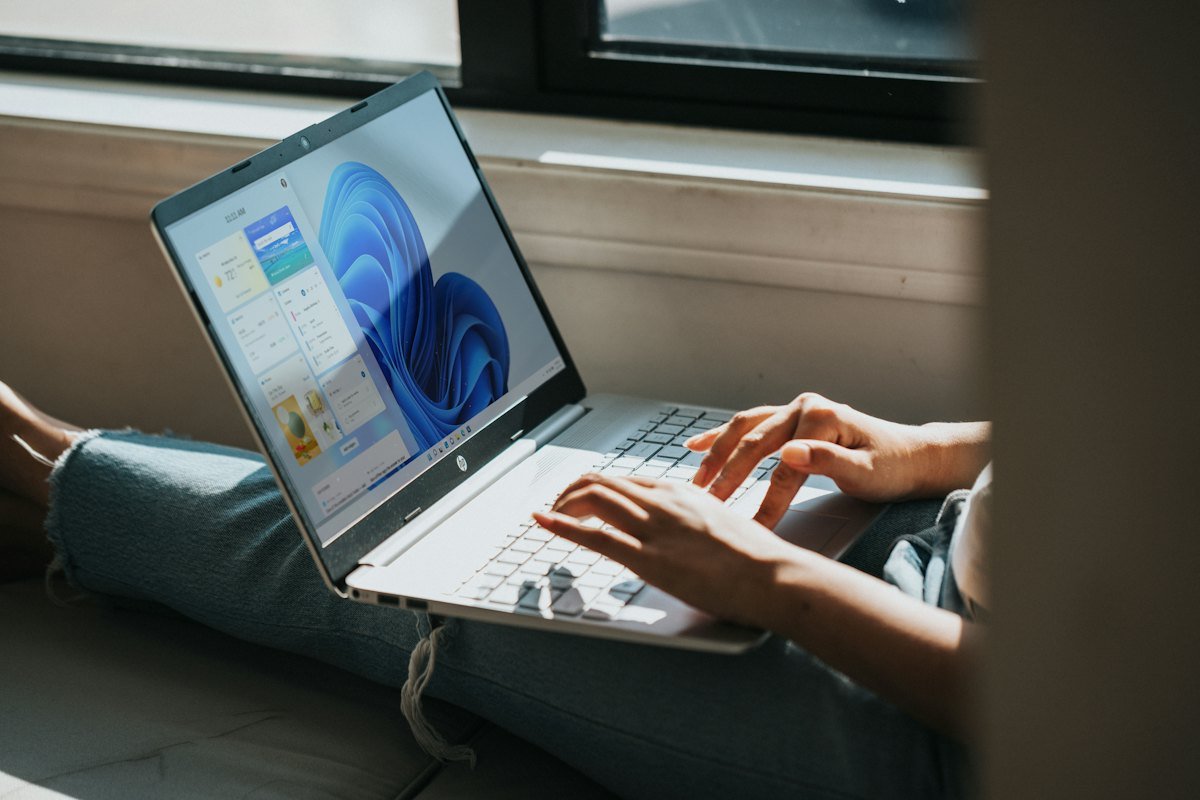 A person using a Windows 11 laptop on their lap