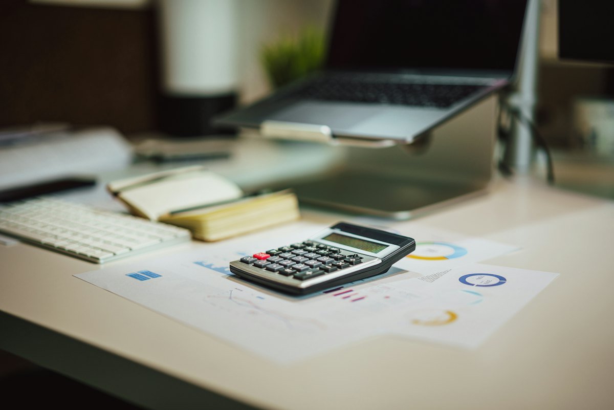 A calculator next to a laptop