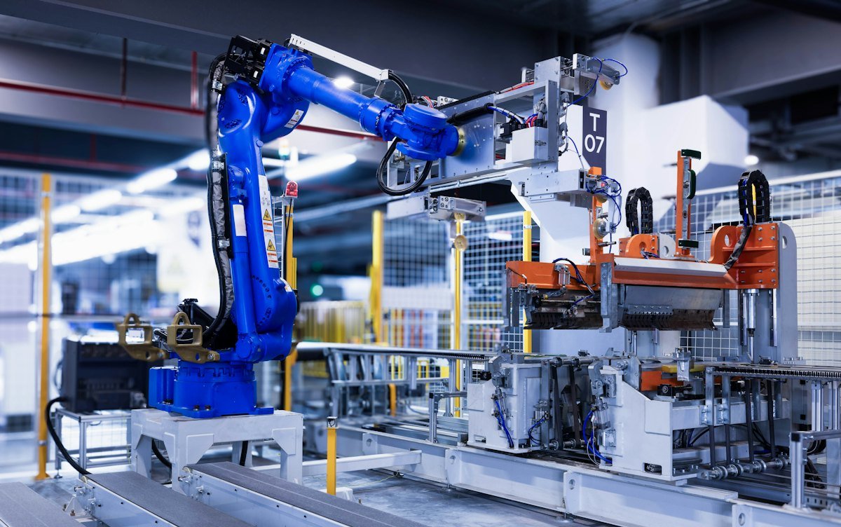 A blue industrial robot arm in a factory