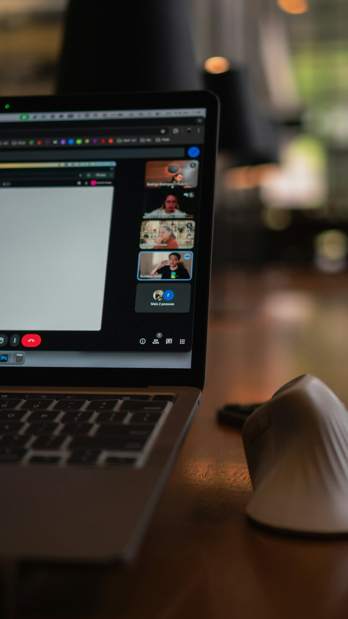 A laptop showing a video conference with many participants